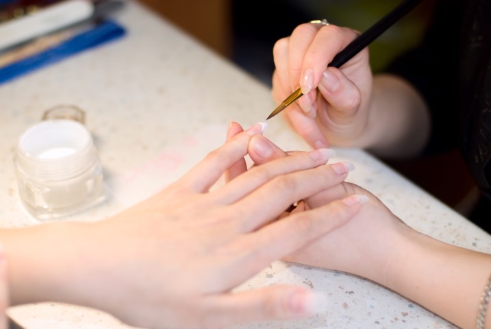 Manicurist treating client at beauty salon