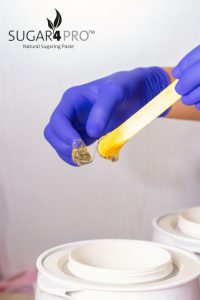 Sugar paste for hair removal in his hand. Concept shugaring